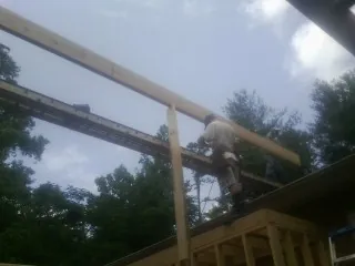 Carpenter setting a ridge beam over a new addition frame — Ice Dam Removal by Roofing Brothers in Mount Royal