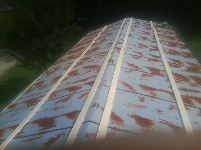 Rusted metal roof panels with new wood purlins before replacement — Storm Damage Roof Repair in Mount Royal by Roofing Brothers