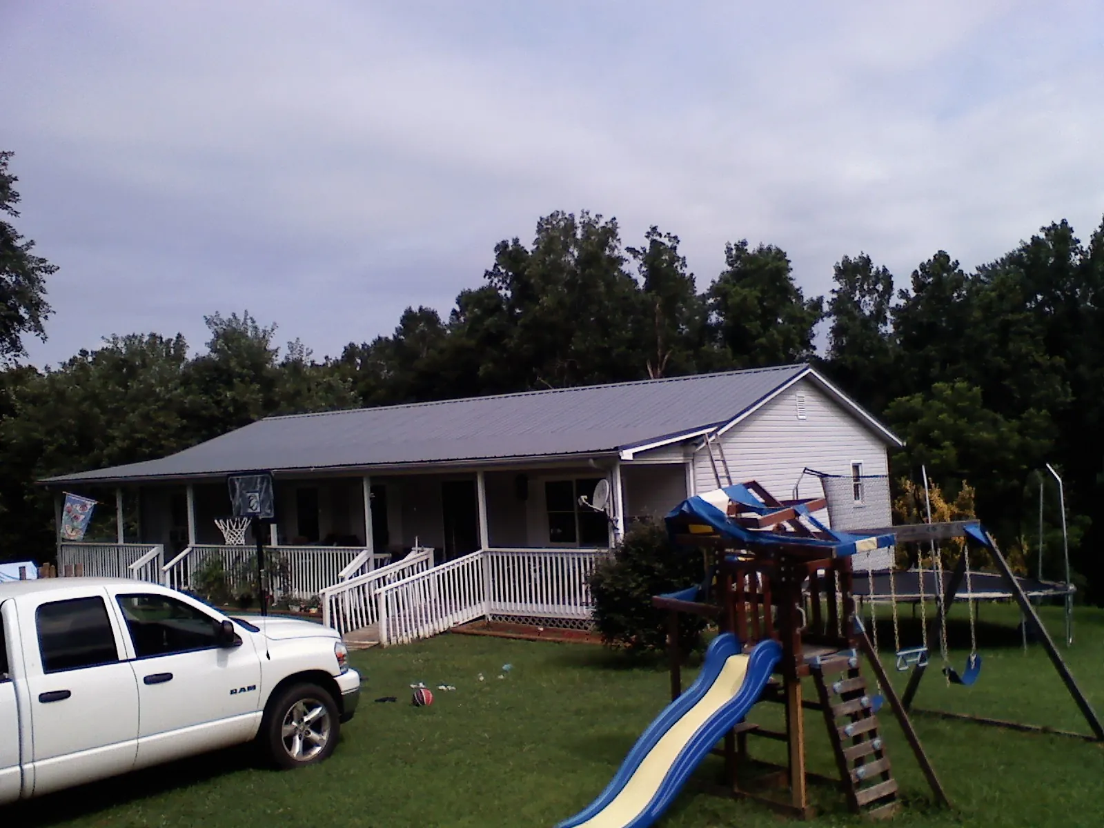 Dark metal roof on a country home with a full length front porch in Mount Royal